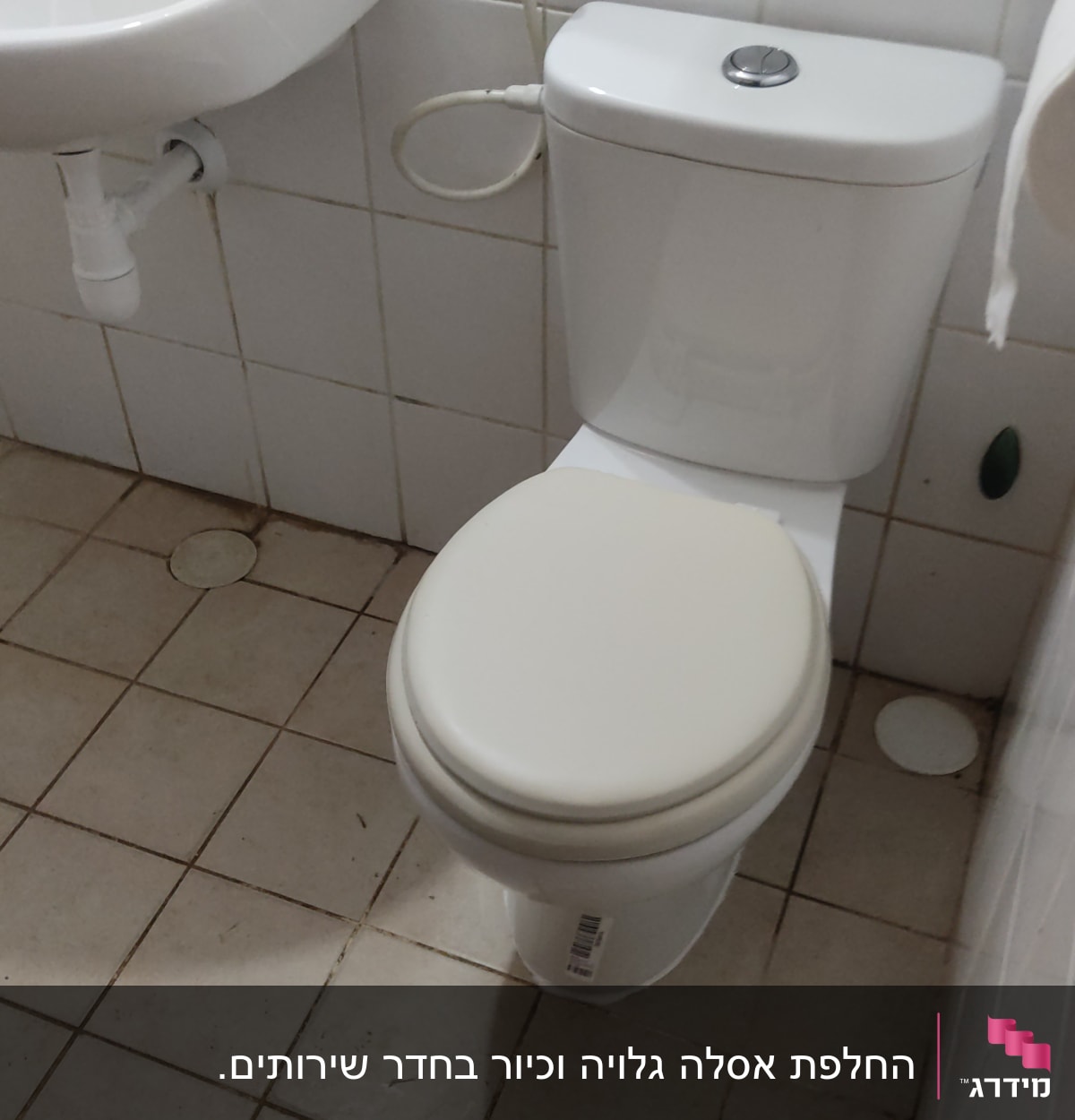 אסלה עם צינור מים ליד כיור בחדר אמבטיה